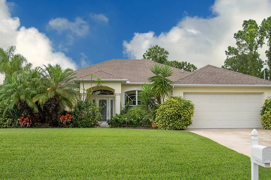 front exterior of off white home with lots of plants and trees in front orlando fl